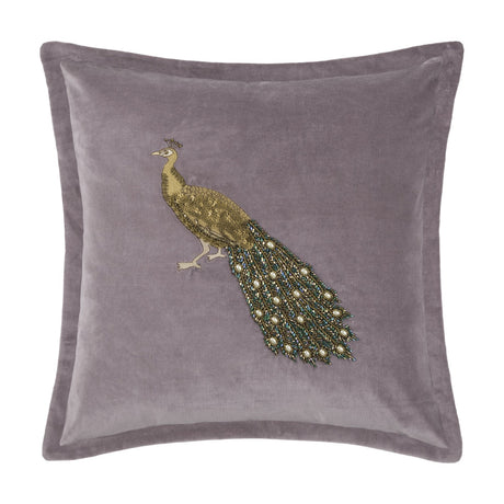 Mayura Animal Velvet Cushion in lavender, square with flanged edge, featuring an embroidered gold-thread peacock with a beaded green, bronze and pearl-white tail, shown on a plain white background.