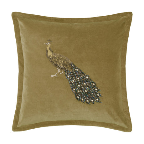 Mayura square velvet cushion in mustard-gold with a hand-embroidered peacock design featuring beaded body, tail, and legs, shown on a plain white background.