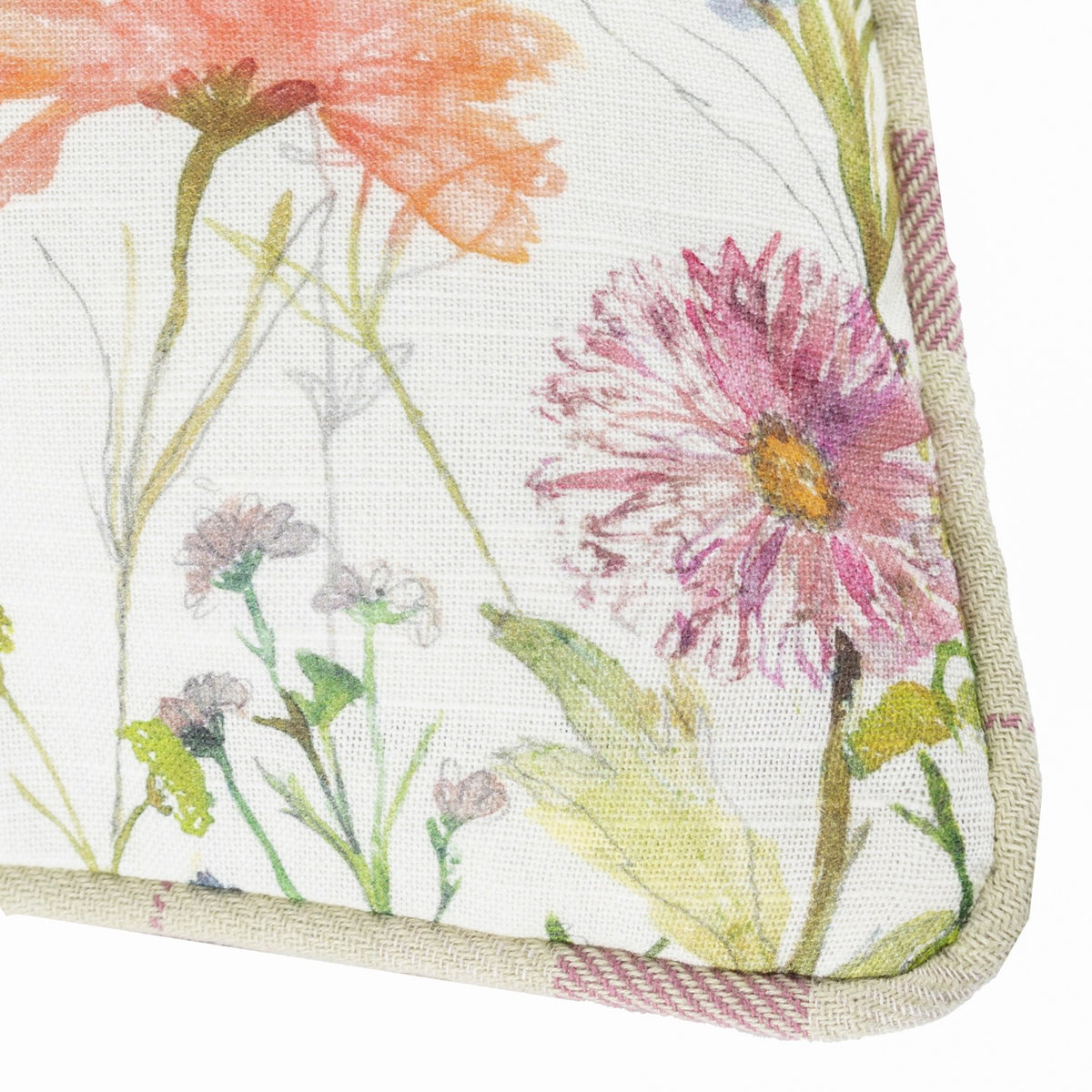 Close-up corner of the Medmerry linen cotton cushion in Elderberry, showing hand-painted pink asters and orange florals on pale linen with pink-and-cream check piping trim.
