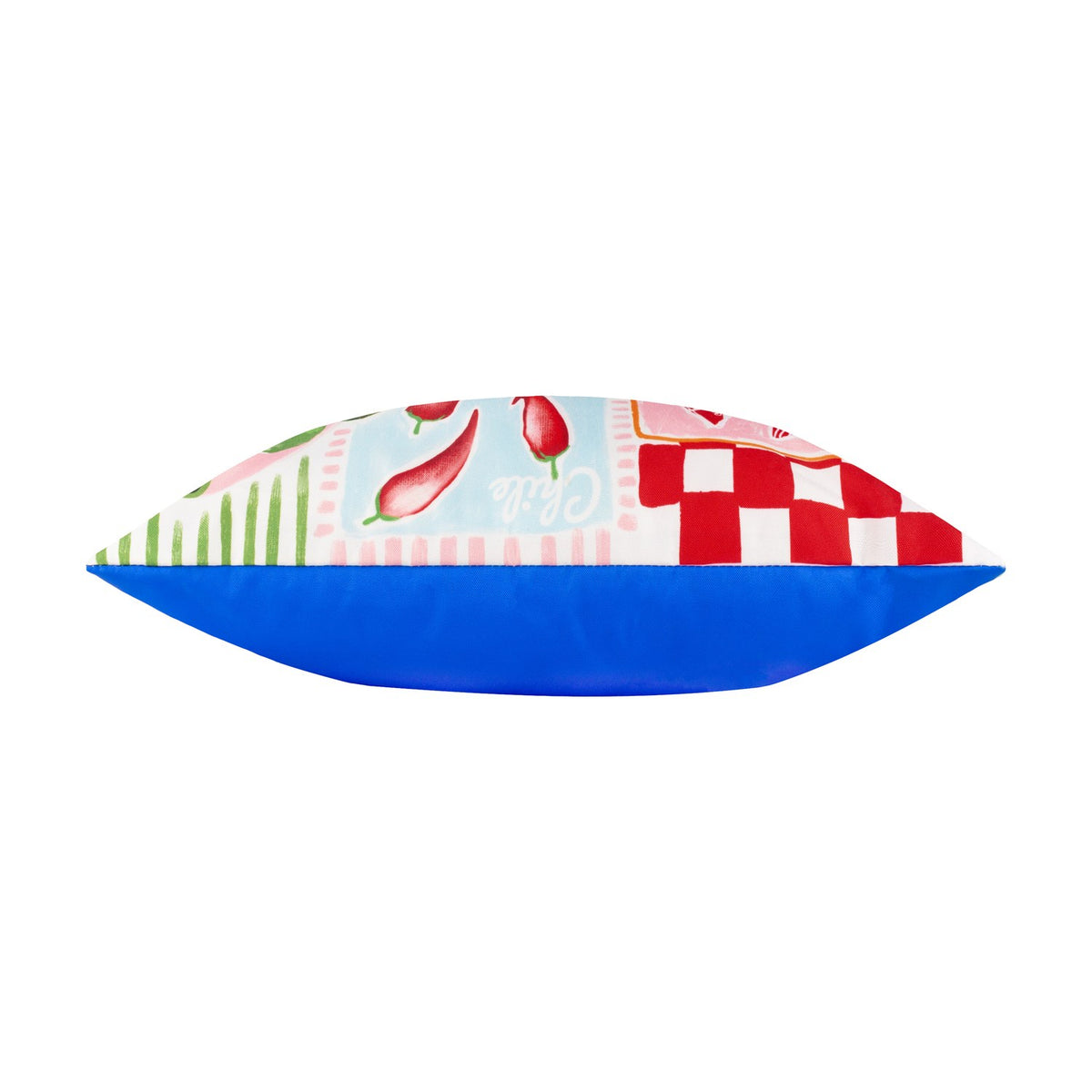 Side view of a Mediterranean Picnic patchwork polyester cushion, showing patterned front with chillies and gingham checks against a plain blue reverse, on a white background.