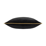 Meridian Plain Velvet Cushion in black, shown side-on to reveal its plump shape and gold piped border trim, set against a plain white background.