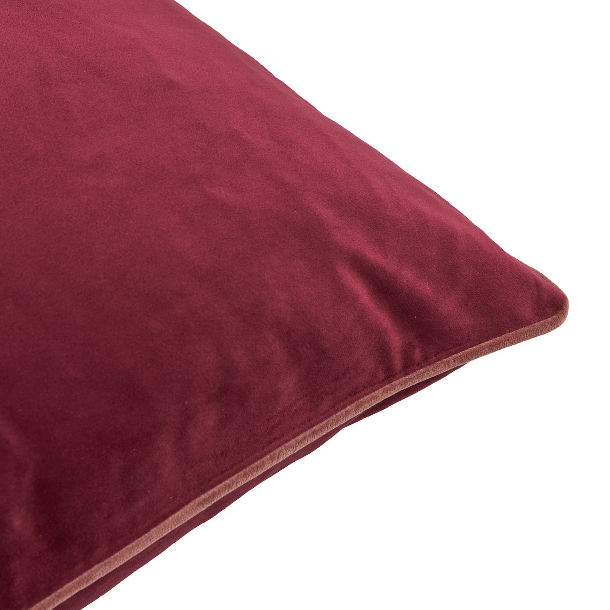 Close-up of the Meridian square velvet cushion in burgundy with contrasting slipper pink piped trim along the edge, shown on a plain white background.