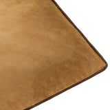 Close-up of the Meridian plain velvet cushion in caramel, showing the soft pile texture and contrasting chocolate-brown piped edge trim on a white background.