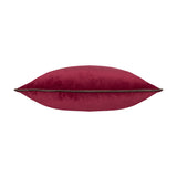 Side view of the Meridian Plain Velvet Cushion in cranberry pink velvet with a contrasting mocha brown piped edge, shown plump and full on a plain white background.