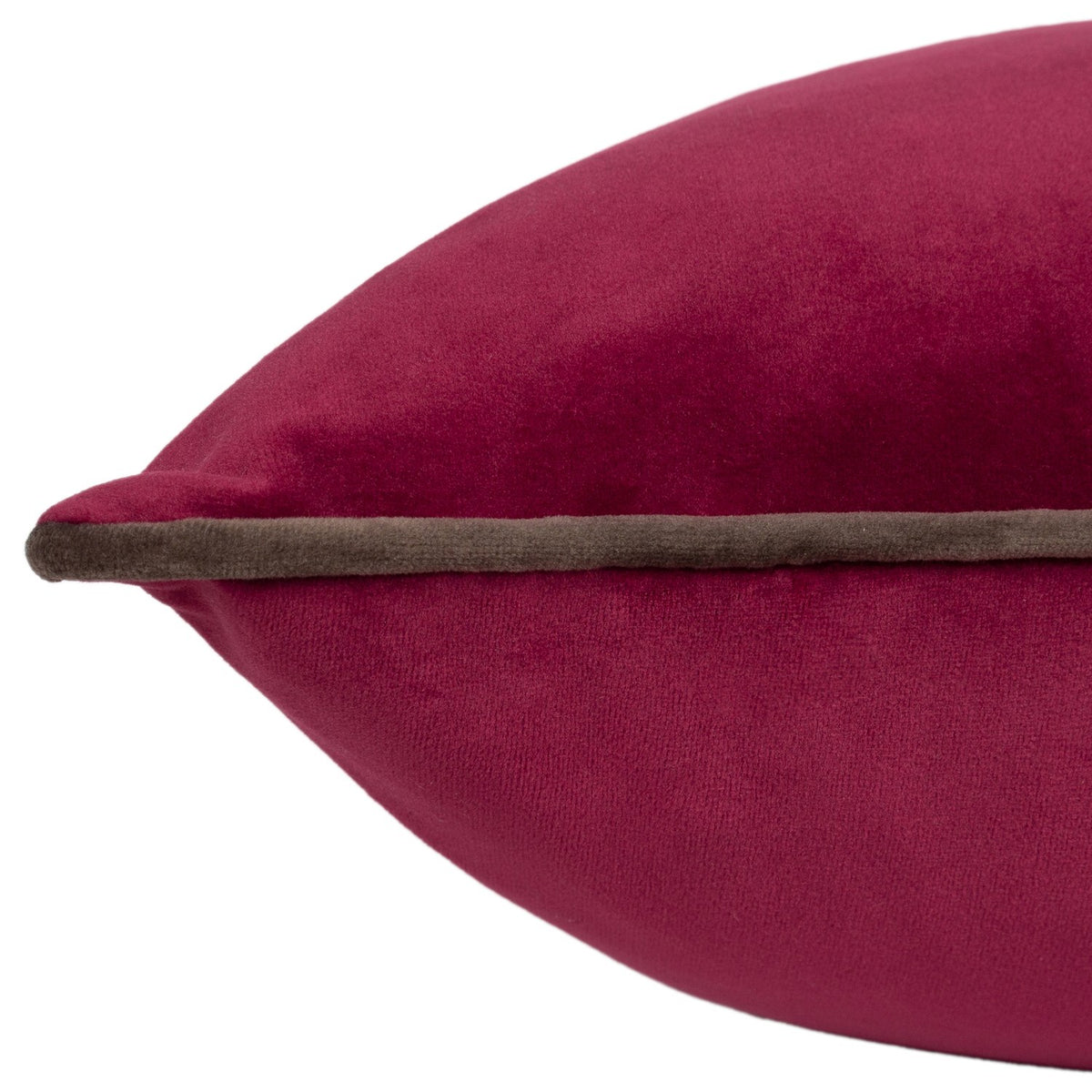 Close-up of the Meridian Plain Velvet Cushion in cranberry pink velvet with a contrasting mocha brown piped edge, shown plump and full against a white background.
