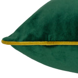 Close-up of the Meridian Plain Velvet Cushion in emerald green, showing the soft velvet-feel fabric and contrasting moss green piped edge against a white background.