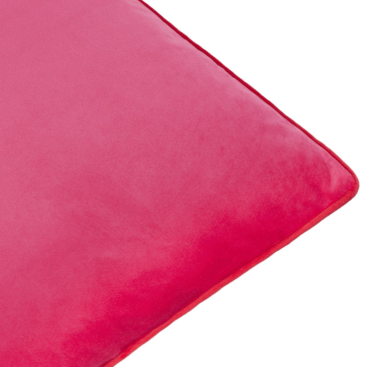 Close-up of the Meridian Plain Velvet Cushion in hot pink velvet with a contrasting red piped trim along the edge, shown on a white background.