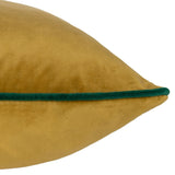 Close-up of the Meridian Plain Velvet Cushion in gold velvet with a contrasting emerald green piped edge, shown against a plain white background.