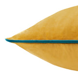 Close-up of the Meridian ochre velvet cushion's pointed corner, showing soft-touch pile and contrasting teal piped trim, on a plain white background.