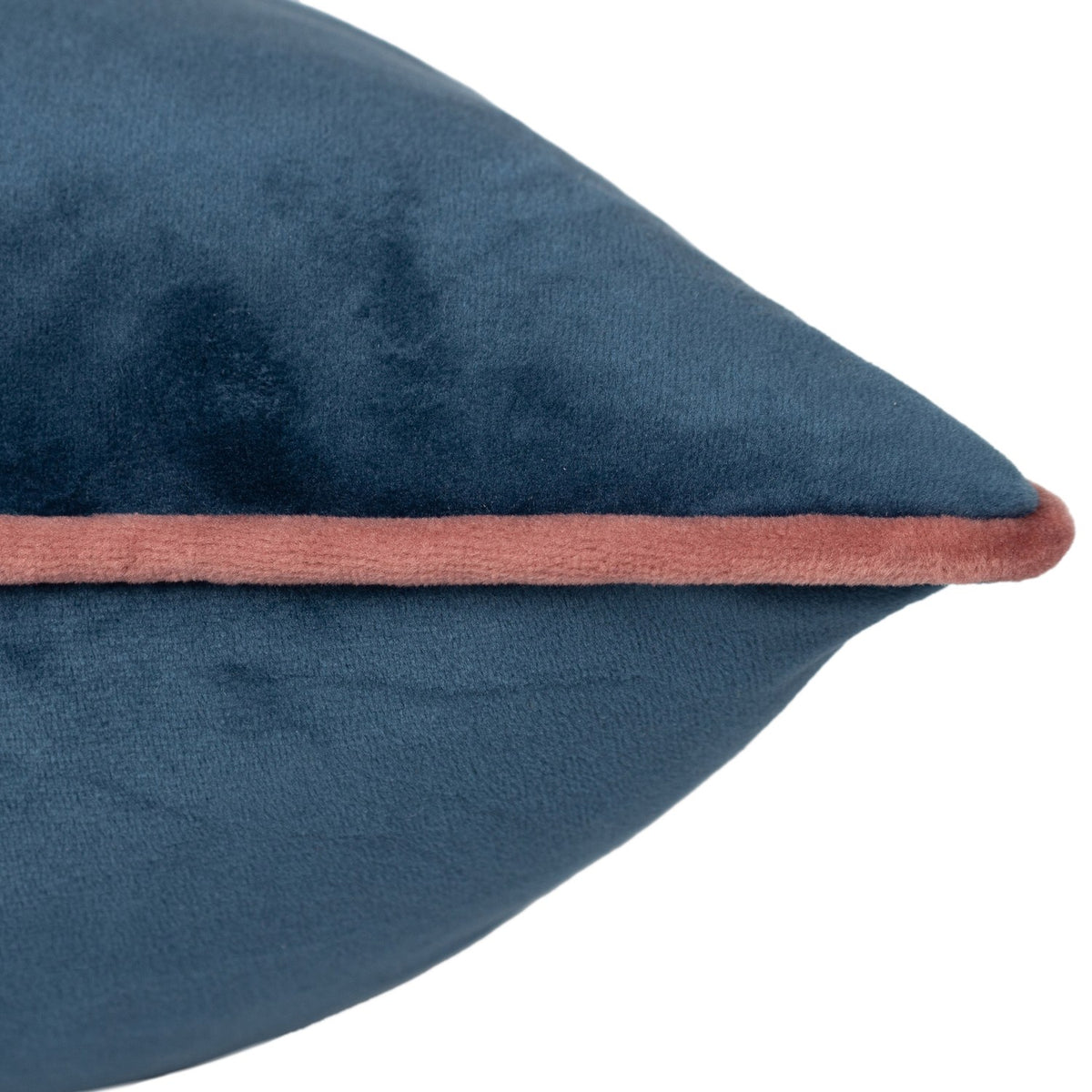 Close-up of the Meridian Plain Velvet Cushion in petrol blue, showing the soft velvet texture and blush pink piped edge along the seam.