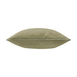 Meridian Plain Velvet Cushion in sage green, shown side-on to reveal its plump velvet form and contrasting piped edge trim, set against a plain white background.