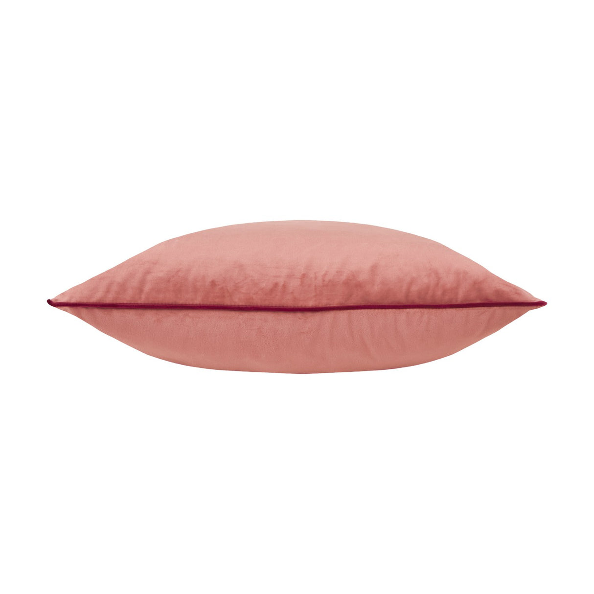 Meridian plain velvet cushion in coral pink, shown side-on with a contrasting burgundy piped edge trim, on a plain white background.