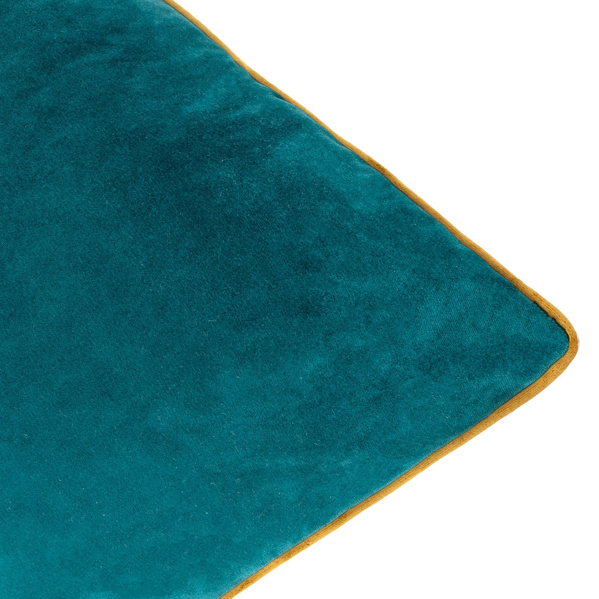 Close-up of the Meridian velvet cushion's corner, showing deep teal velvet fabric with a contrasting ochre-gold piped edge trim on a white background.