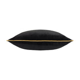 Meridian Plain Velvet Cushion in black, shown side-on to reveal its plump shape and gold piping trim along the seam, set against a plain white background.