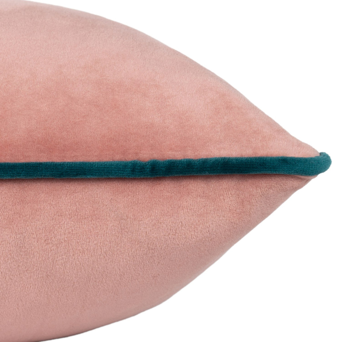Close-up of the Meridian velvet cushion's pointed corner, showing blush pink fabric with a contrasting deep teal piped edge, on a plain white background.