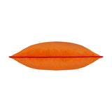 Meridian Plain Velvet Cushion in clementine orange with a hot pink piped edge, shown on its side on a plain white background.