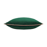 Meridian velvet cushion in emerald green, shown side-on to reveal its plump square shape with a blush pink piped edge trim, set against a plain white background.