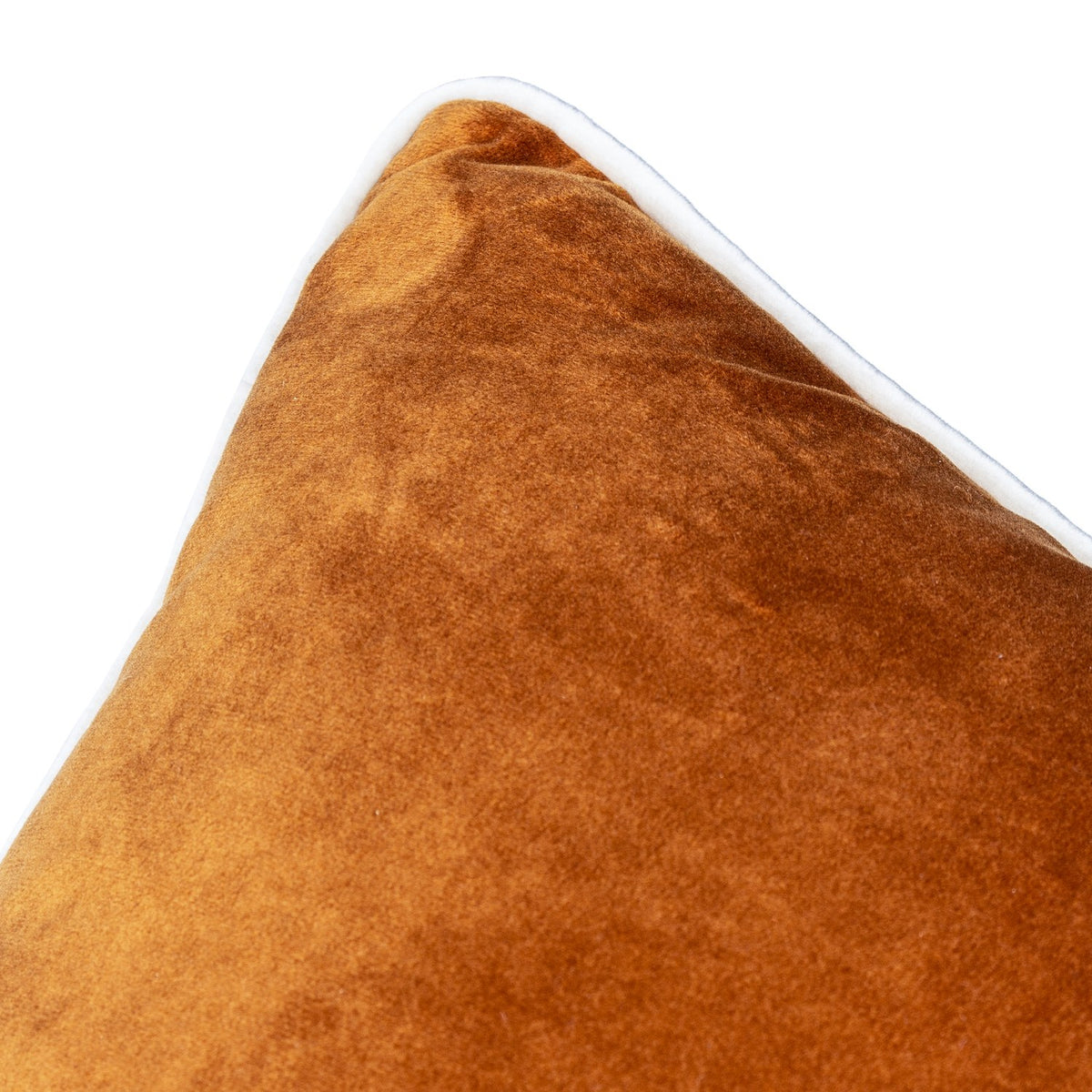 Close-up of the Meridian Plain Velvet Cushion in ginger, showing burnt-orange velvet texture and the contrasting ecru piped edge, against a white background.
