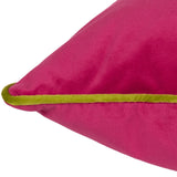 Close-up of the Meridian Plain Velvet Cushion in hot pink, showing the soft velvet texture and contrasting lime green piped edge on a plain white background.
