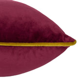 Close-up of the Meridian Plain Velvet Cushion in maroon velvet with moss green piped edging, shown against a plain white background.