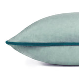 Close-up of the Meridian Plain Velvet Cushion in mineral blue, showing the soft velvet-feel fabric and contrasting teal piped edge on a plain white background.