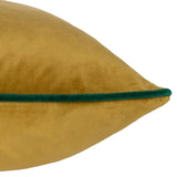 Close-up of the Meridian Plain Velvet Cushion in mustard-gold velvet with a contrasting emerald green piped edge, shown against a plain white background.