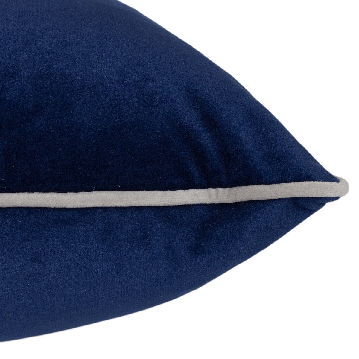 Close-up of the Meridian Plain Velvet Cushion in navy blue, showing the plush velvet-feel fabric and pointed corner with a silver-grey piped edge on a white background.