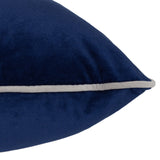 Close-up of the Meridian Plain Velvet Cushion in navy blue, showing the plush velvet-feel fabric and pointed corner with a silver-grey piped edge on a white background.