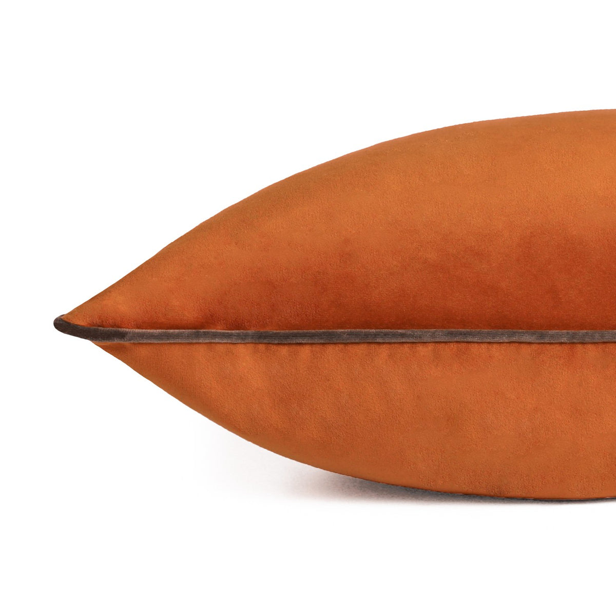 Close-up of the Meridian Plain Velvet Cushion in pumpkin orange velvet with a mocha brown piped edge, shown against a plain white background.