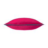 Meridian Plain Velvet Cushion in raspberry pink with contrasting teal piped edge trim, shown side-on to highlight its plump velvet shape, on a plain white background.