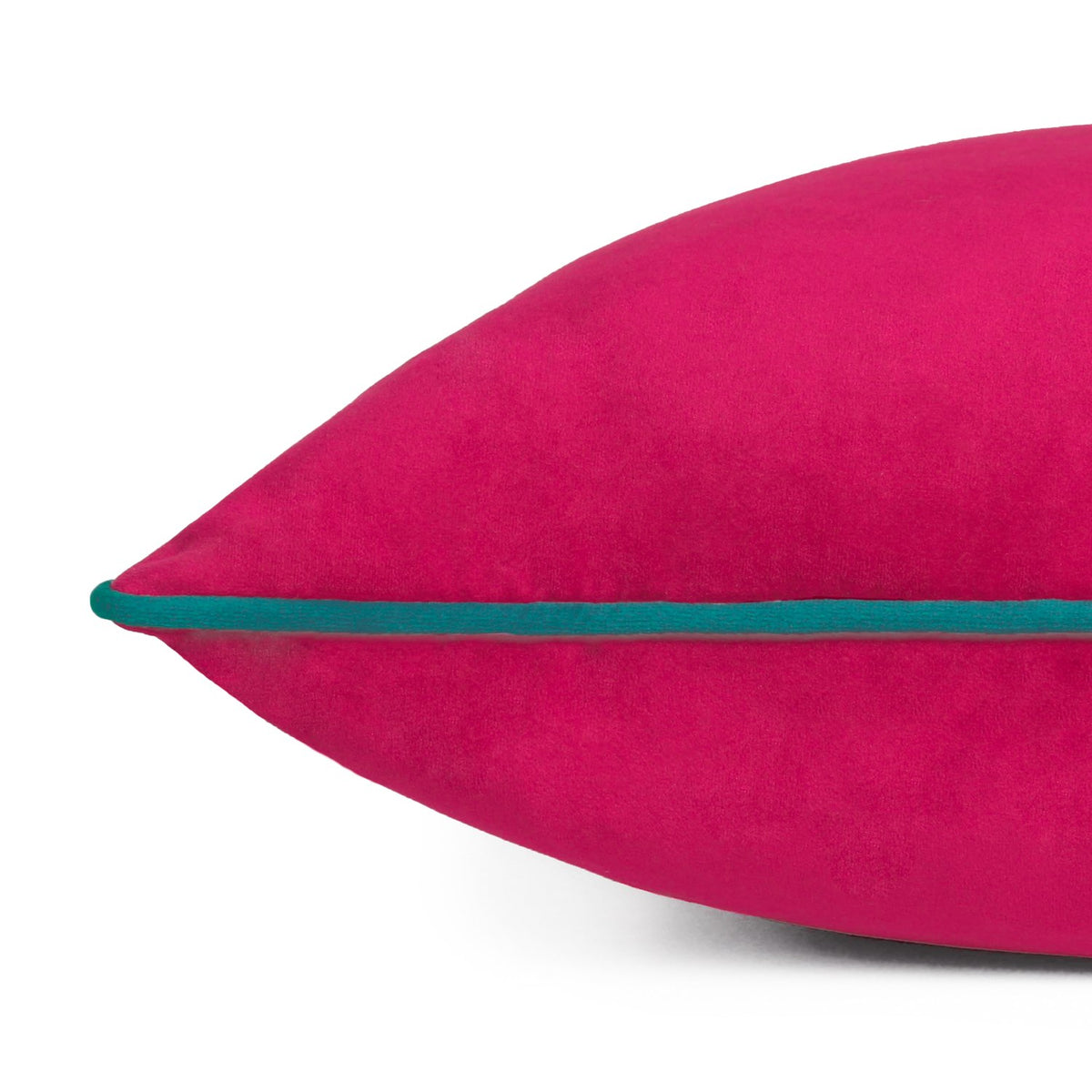 Close-up of the Meridian velvet cushion in raspberry pink with a contrasting teal piped edge along the seam, shown on a plain white background.