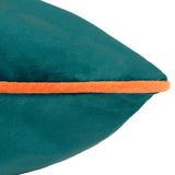 Close-up of the Meridian Plain Velvet Cushion in teal, showing the corner with contrasting clementine orange piping, set against a plain white background.