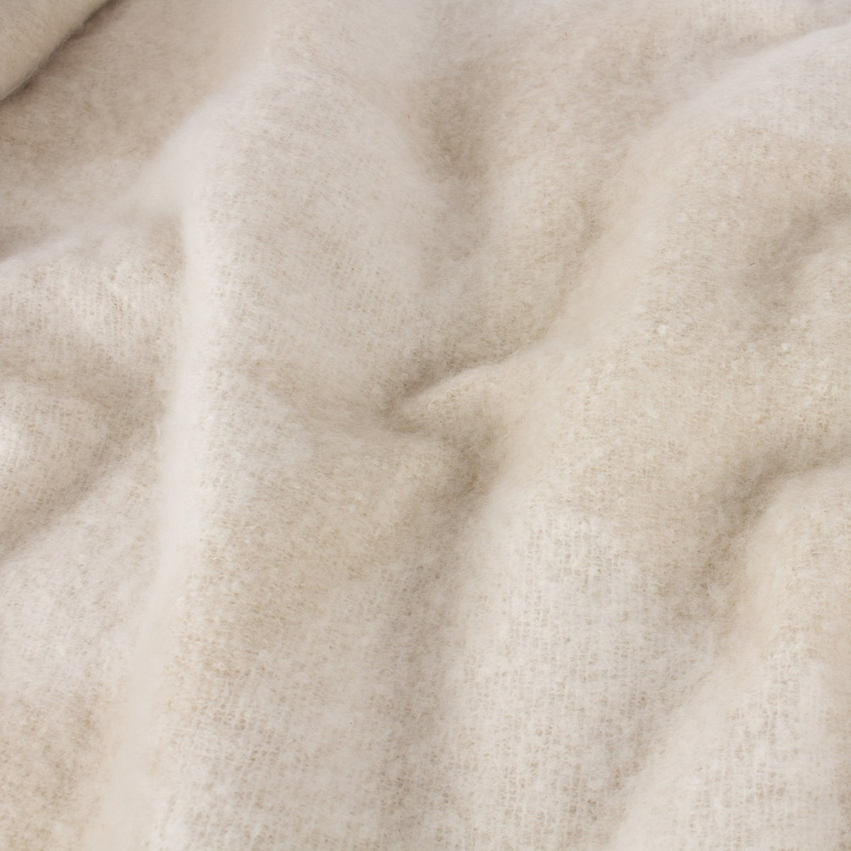 Close-up of the Meta Jacquard Polyester Throw in natural, showing soft brushed mohair-like texture with subtle jacquard weave in draped folds.