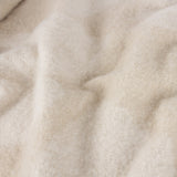 Close-up of the Meta Jacquard Polyester Throw in natural, showing soft brushed mohair-like texture with subtle jacquard weave in draped folds.