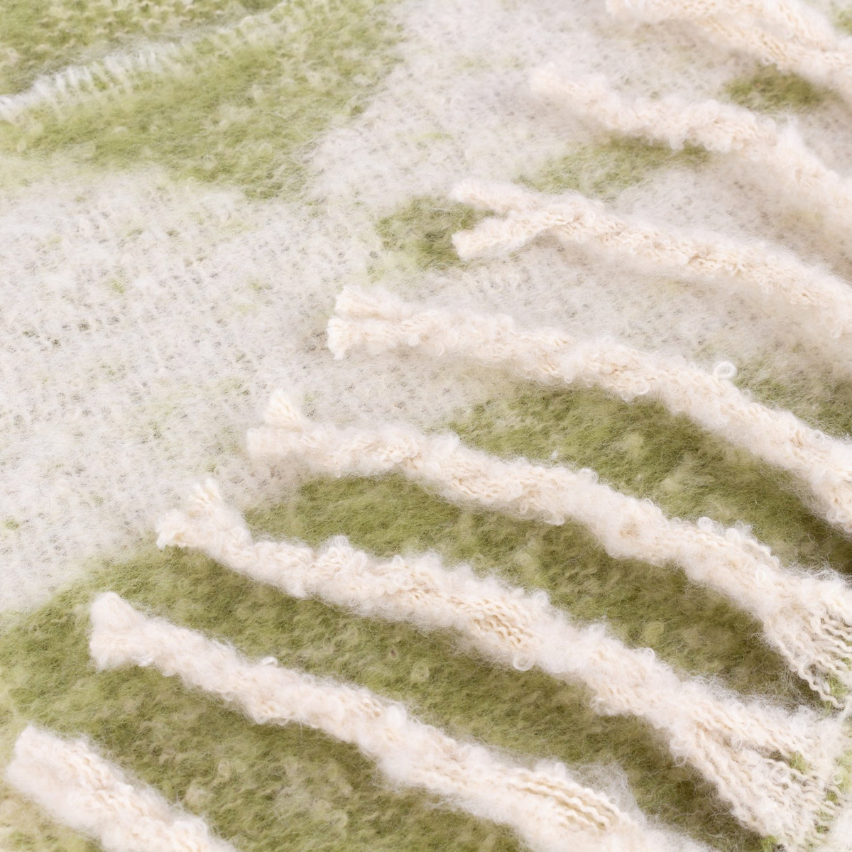 Close-up of the Meta Jacquard Polyester Throw in olive, showing a faux mohair brushed pile with an abstract woven jacquard pattern in green and cream.