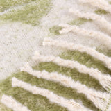 Close-up of the Meta Jacquard Polyester Throw in olive, showing a faux mohair brushed pile with an abstract woven jacquard pattern in green and cream.