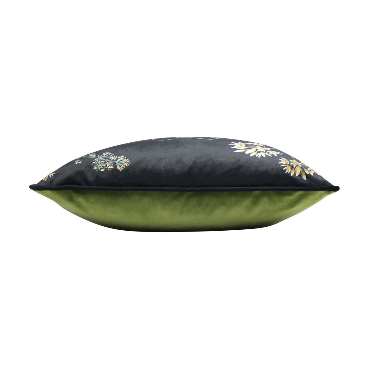 Midnight Garden velvet cushion shown side-on, with black floral-printed front and plain green velvet back, edged in black piping, on a white background.