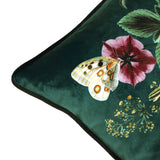 Close-up of the Midnight Garden Animal Velvet Cushion in green, showing velvet fabric with a butterfly, pink flower and piped edge detail.