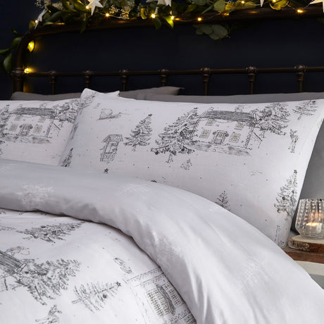 Midwinter Toile Printed Woodland Duvet Cover Set in Snow, white cotton bedding with grey line-drawn cottages, fir trees and woodland animals, styled on a bed with matching pillowcase.