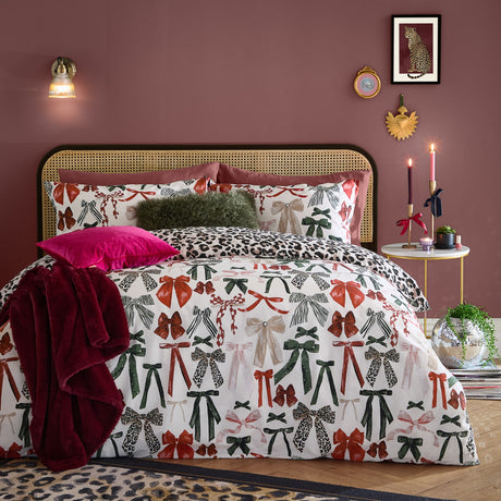 Mila Bows Reversible Animal Duvet Cover Set in Leopard, shown on a bed with bow-print pillowcases and matching leopard-print reverse, styled in a pink bedroom.