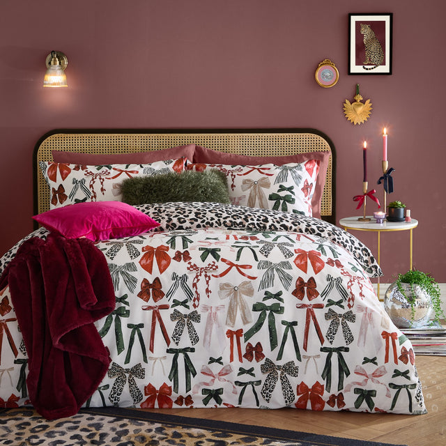 Mila Bows Reversible Animal Duvet Cover Set in Leopard, shown on a bed with bow-print pillowcases and matching leopard-print reverse, styled in a pink bedroom.