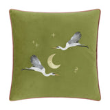 Moonlit Flight Animal Velvet Cushion in olive green, 45 x 45cm, with embroidered cranes in flight, a gold crescent moon and scattered stars, pink piped edge, shown on a plain white background.