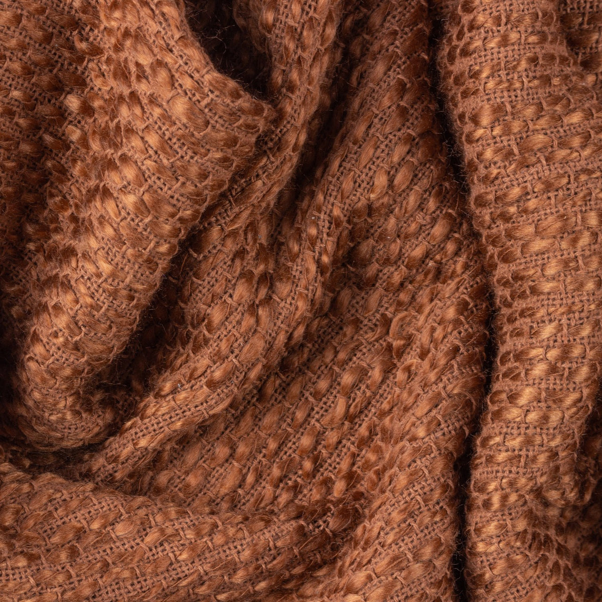 Close-up of the Morni Plain Polycotton Throw in Hazel, showing a chunky basketweave texture in warm brown, draped with soft folds.
