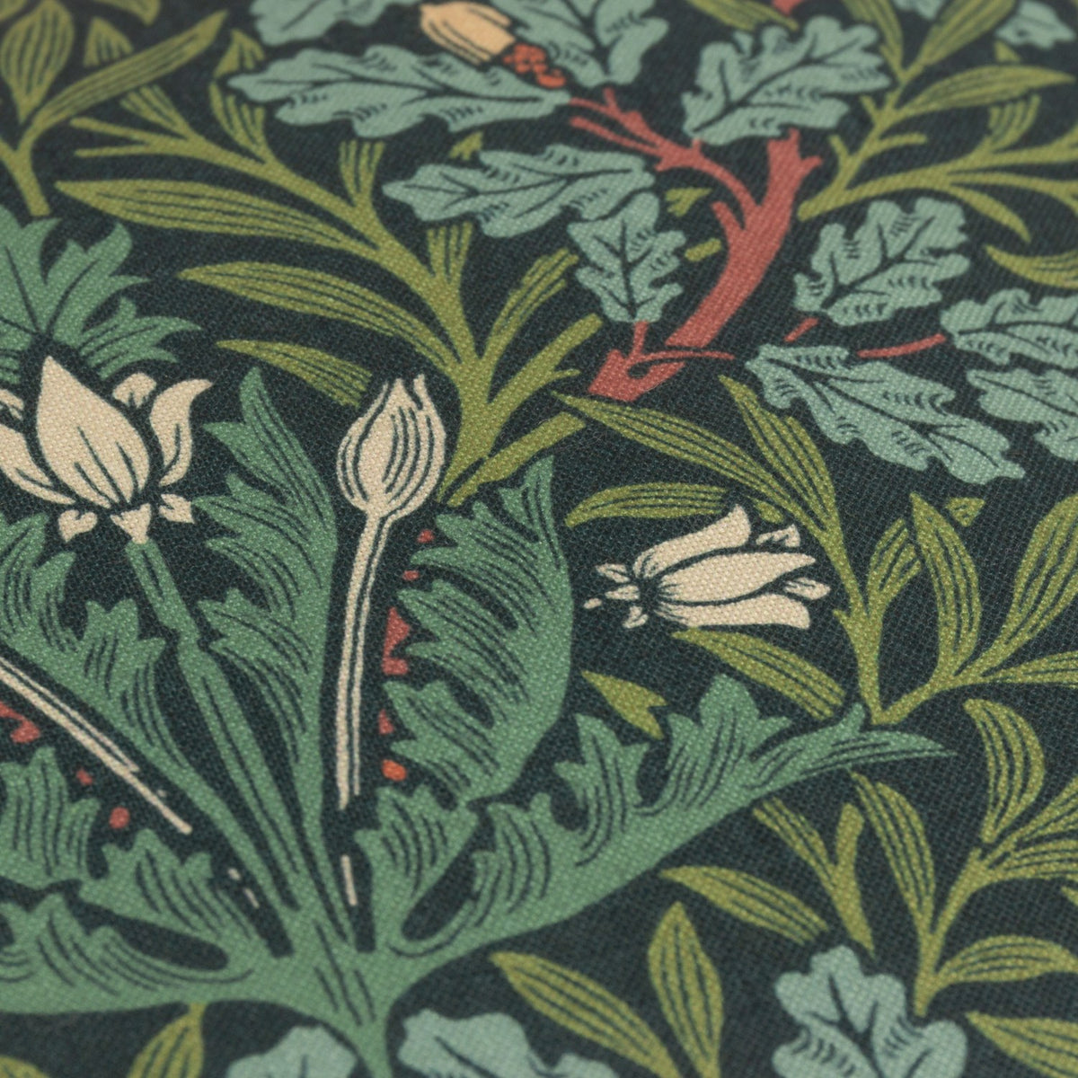 Close-up of the Multi Acorn Woodland polyester cushion in Thyme/Forest green, showing dense oak leaf, acorn, and floral bud print detail.