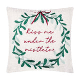 Square cream boucle cushion with an embroidered green mistletoe wreath, red ribbon and "Kiss me under the mistletoe" text, shown on a plain white background.