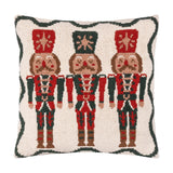 Square tufted cotton cushion featuring three red and green nutcracker soldiers on a cream ground with a scalloped green border, shown against a plain white background.