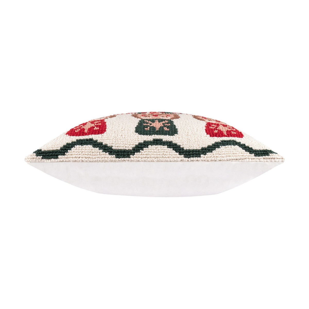 Side view of the Nutcracker Trio Tufted Cotton Cushion, showing its plump square shape with a tufted cream, red and green patterned edge and plain white reverse, set against a white background.