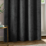 Neptune Velvet Fully Lined Eyelet Curtains in charcoal, showing raised honeycomb-textured fabric with eyelet header, styled in a living room setting.