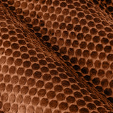 Close-up of Neptune Velvet Eyelet Curtains in copper, showing a raised honeycomb pattern in the polyester velvet fabric with soft folds catching the light.