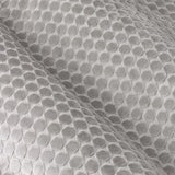 Close-up of Neptune silver grey cut velvet eyelet curtain fabric, showing a raised geometric dot pattern with light-catching pile texture and soft folds.